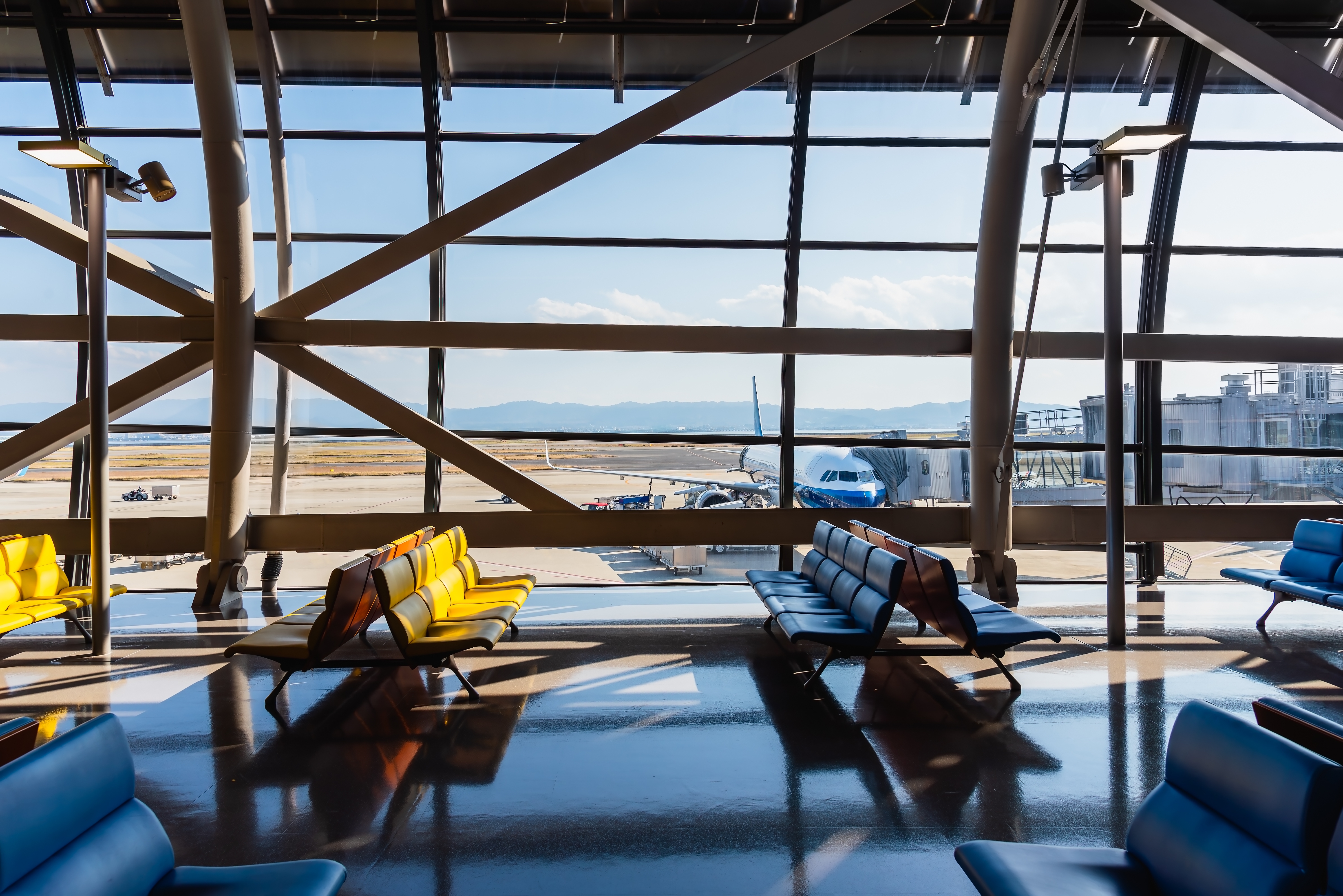 Airport terminal glass window with view of airplane, airport interior departure hall for travel and transportation concept.
