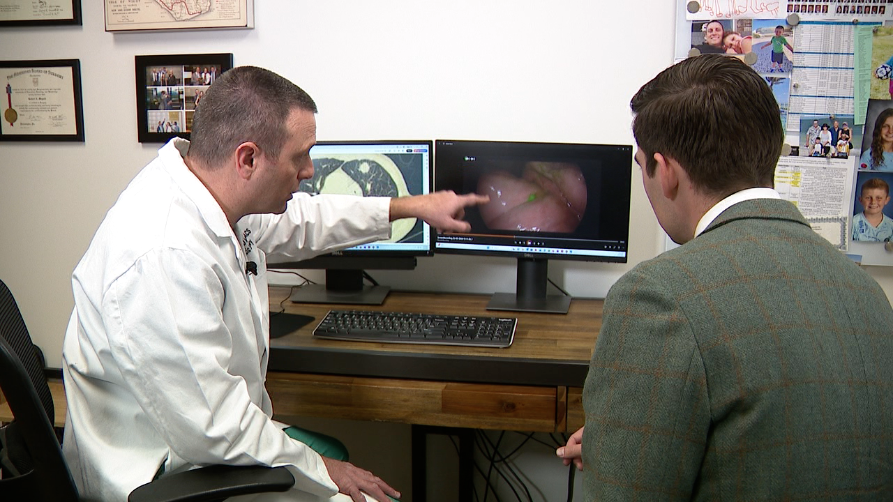 Dr. Robert Meguid points out cancer cells glowing on a patient's lungs, after using imaging agent pafolacianine. 