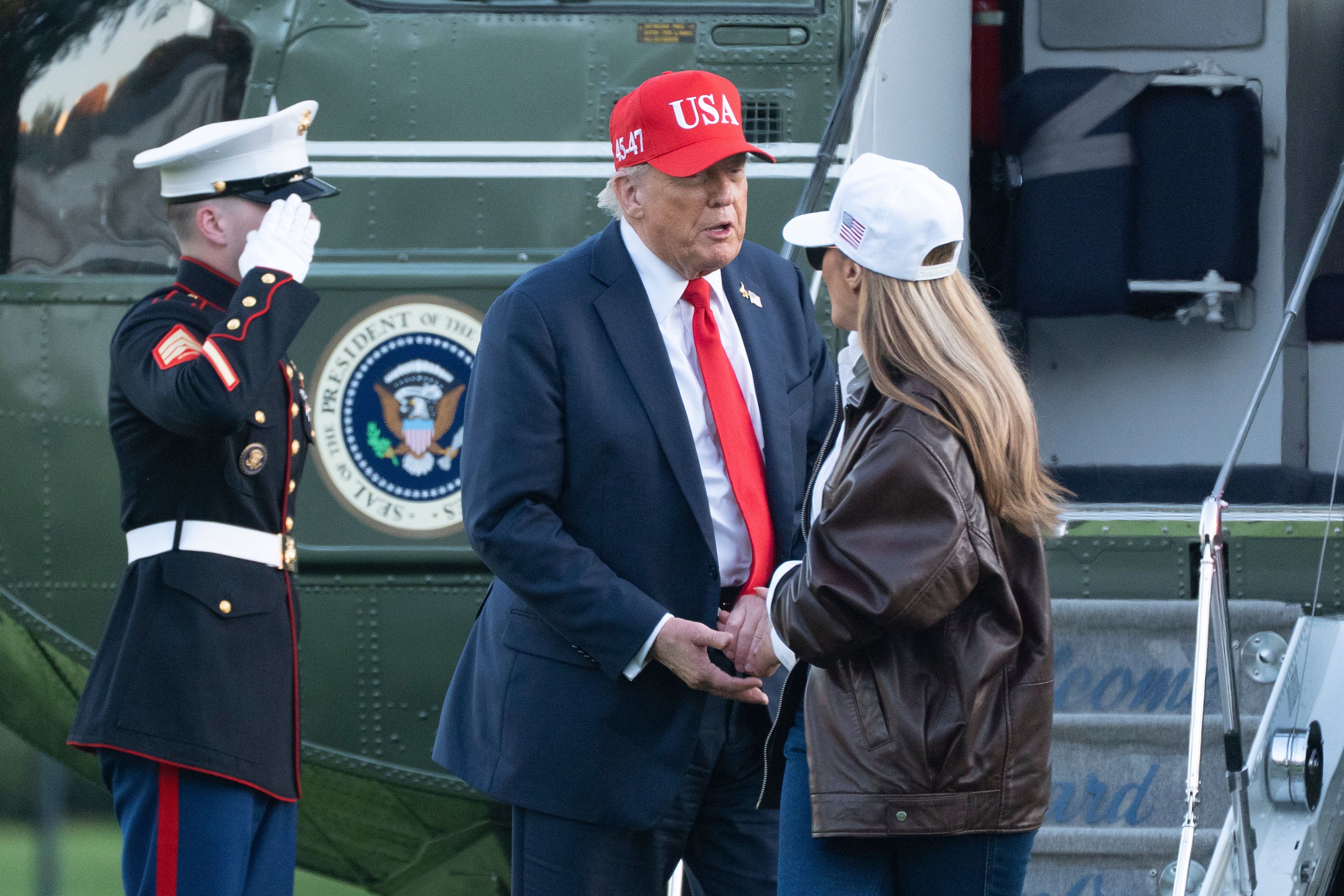 President Donald Trump talks to first lady Melania Trump as they disembark Marine One upon arrival at the White House in Washington, Sunday, Oct. 5, 2025. 