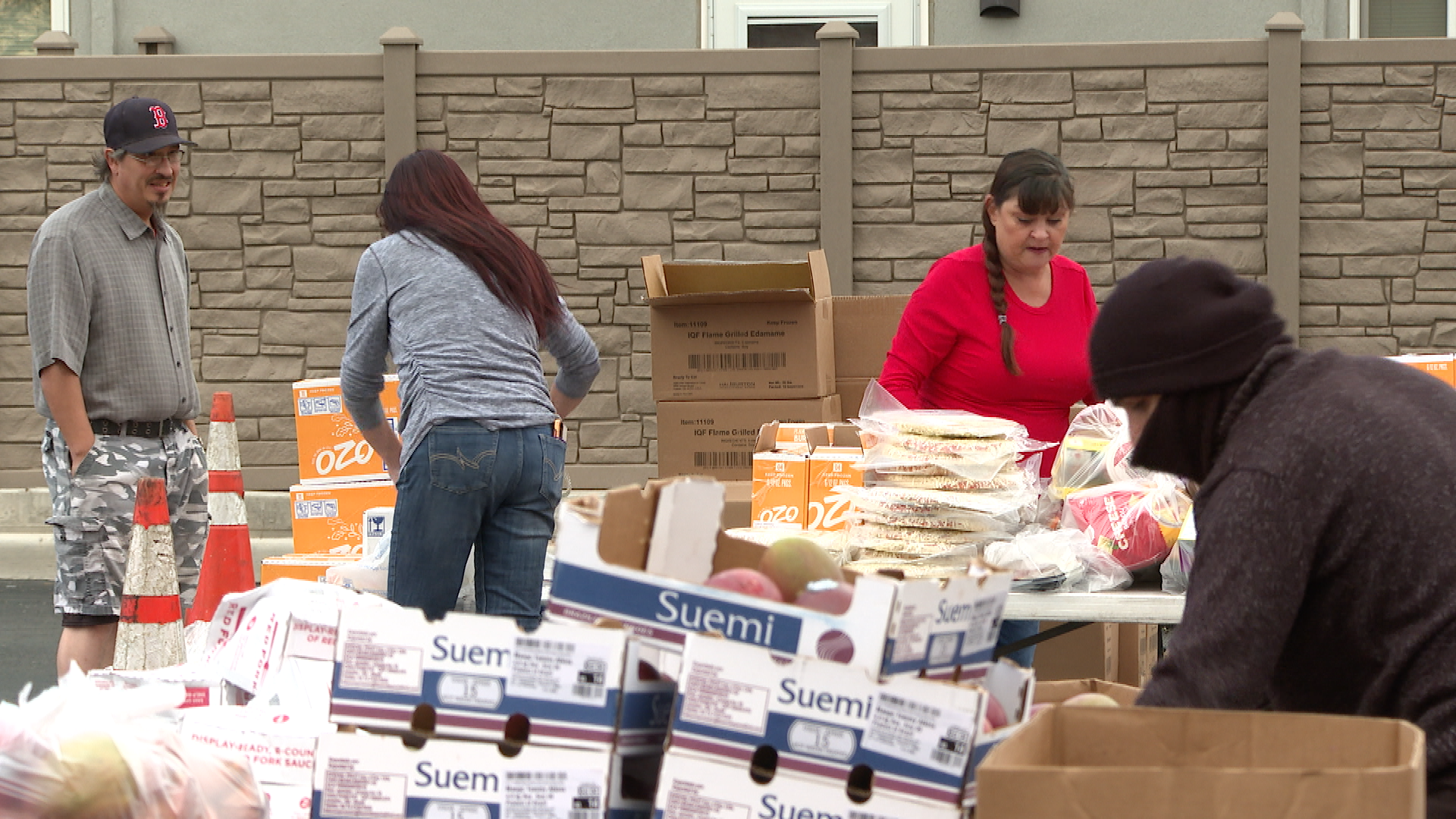 Volunteers with Pueblo United serve food in a drive through 