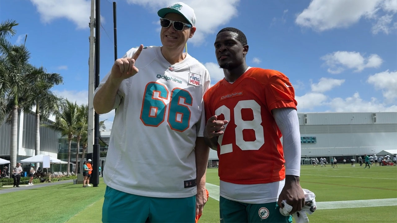Miami Dolphins superfan Ian 'Big E' Berger poses with running back DeVon Achane.
