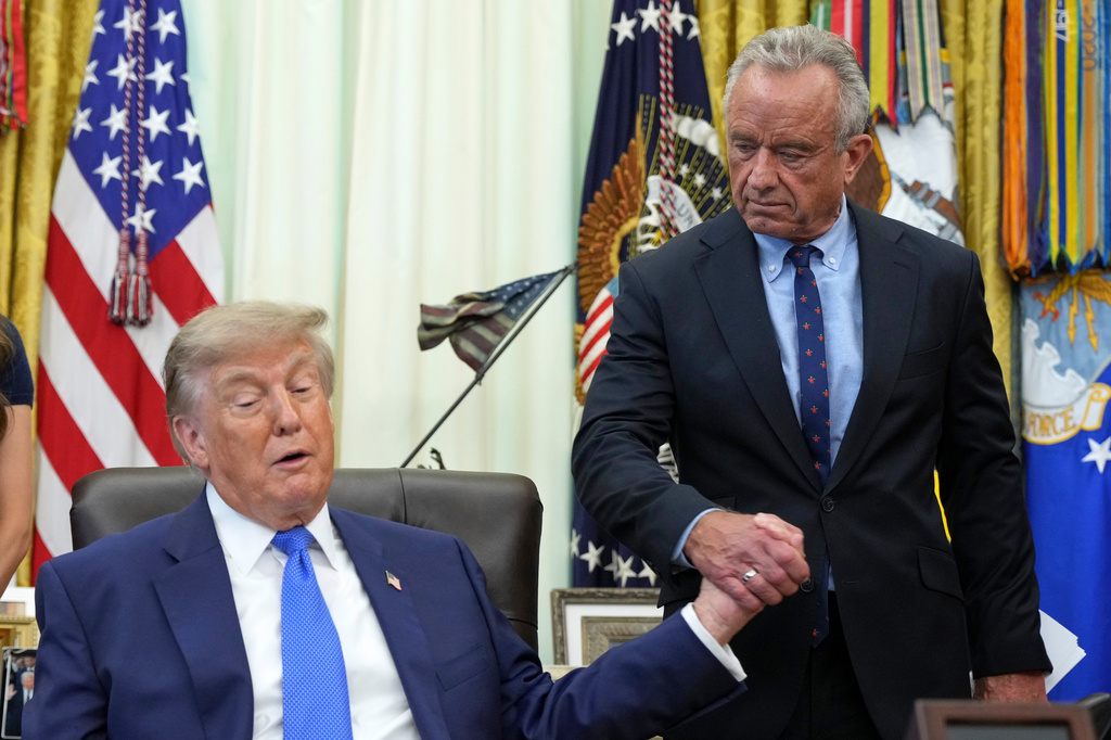 President Donald Trump, left, shakes the hand of Health and Human Services Secretary Robert F. Kennedy Jr. during a meeting to sign an executive order about vaccines, Monday, Aug. 10, 2026, in the Oval Office of the White House in Washington.
