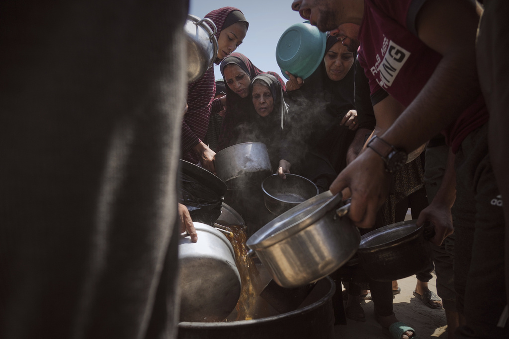 Displaced Palestinians receive donated food at a community kitchen in Gaza City, northern Gaza Strip.
