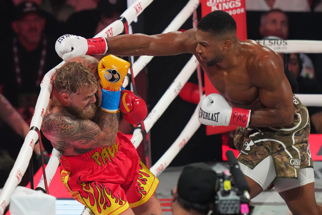 Anthony Joshua, right, punches Jake Paul during their heavyweight boxing match, Friday, Dec. 19, 2025, in Miami, Fla.