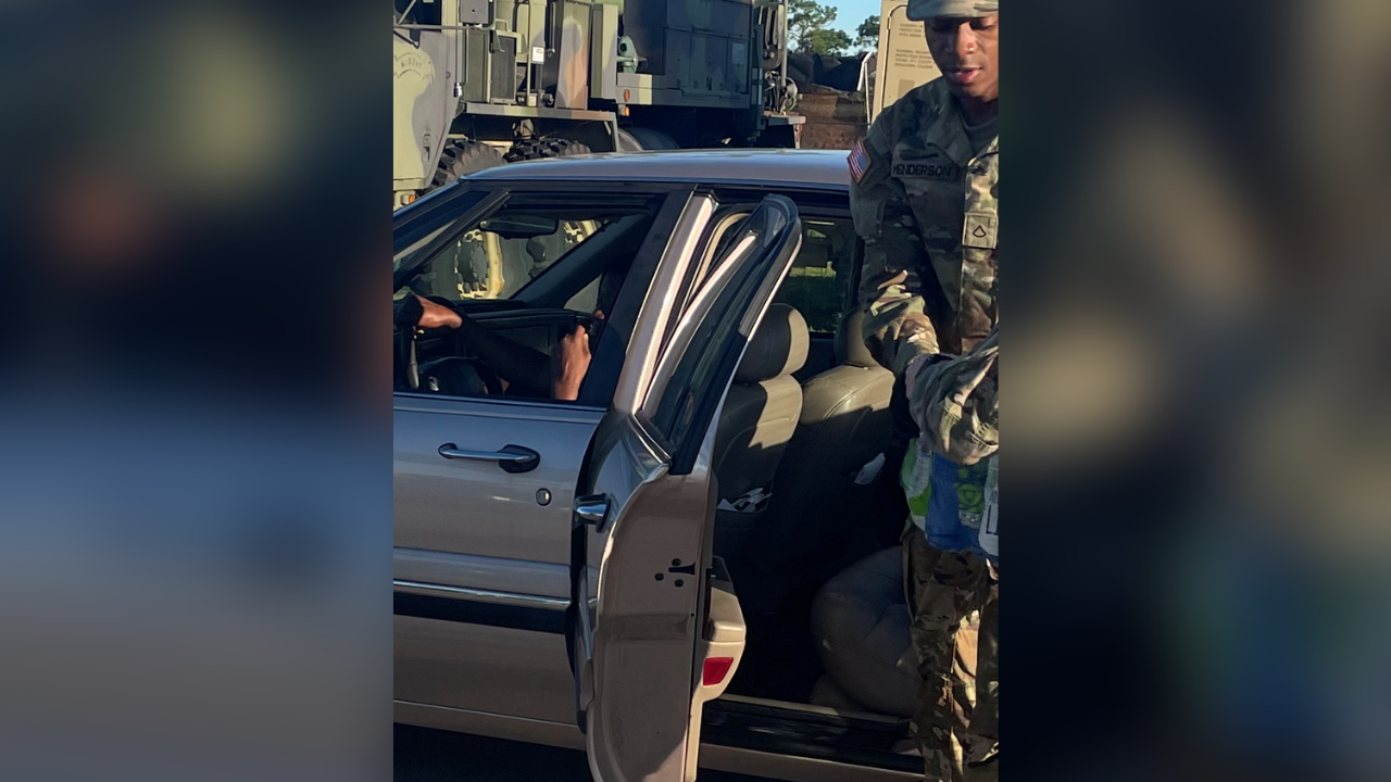 Florida National Guard members load a car with water, food and ice