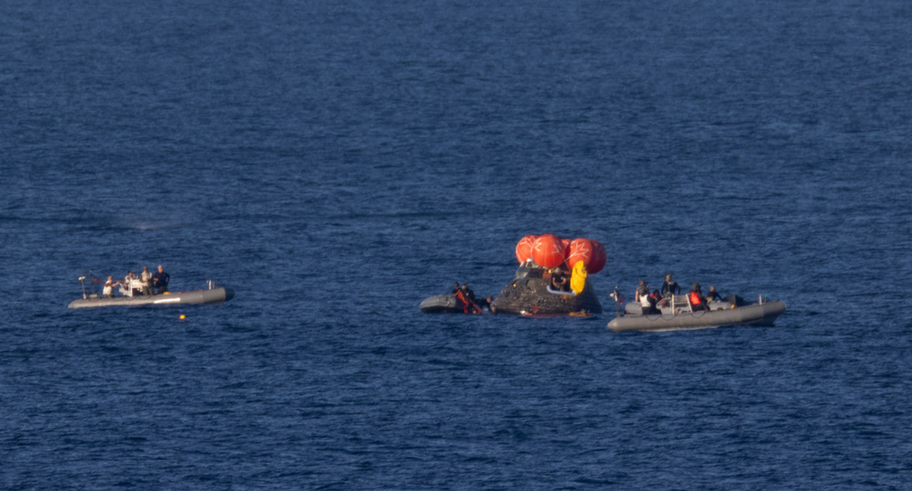 In this photo provided by NASA, recovery teams work to secure the Orion spacecraft carrying Artemis II crewmembers after splashdown in the Pacific Ocean off the coast of California, Friday, April 10, 2026. 