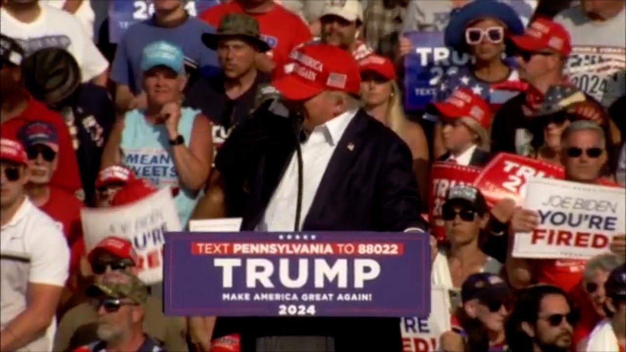Trump Holds Ear after grazed by bullet
