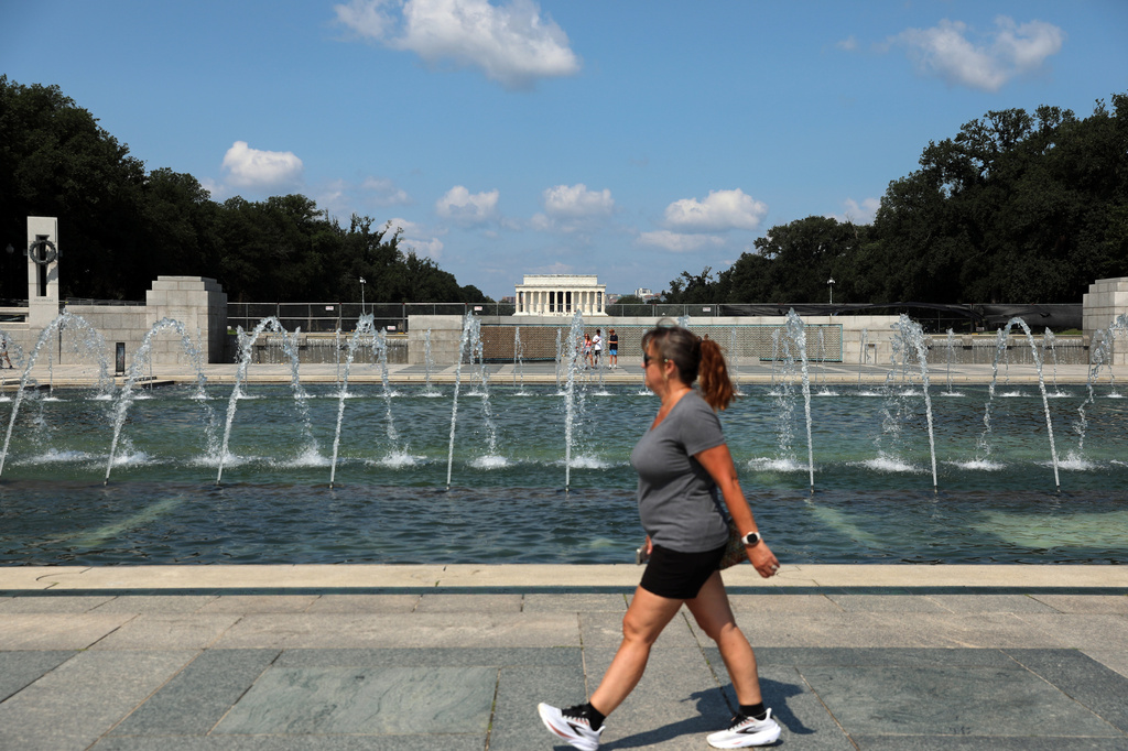 A woman walks near the fountain at the WWII Memorial, in Washington, Wednesday, July 29, 2026.