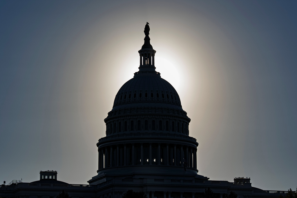 The U.S. Capitol is silhouetted by the stark glare of the morning sun as a government shutdown begins its tenth day, in Washington, Friday, Oct. 10, 2025. 