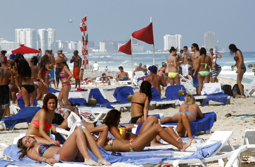 In this file photo, people fill the beach during Spring Break in Mexico.