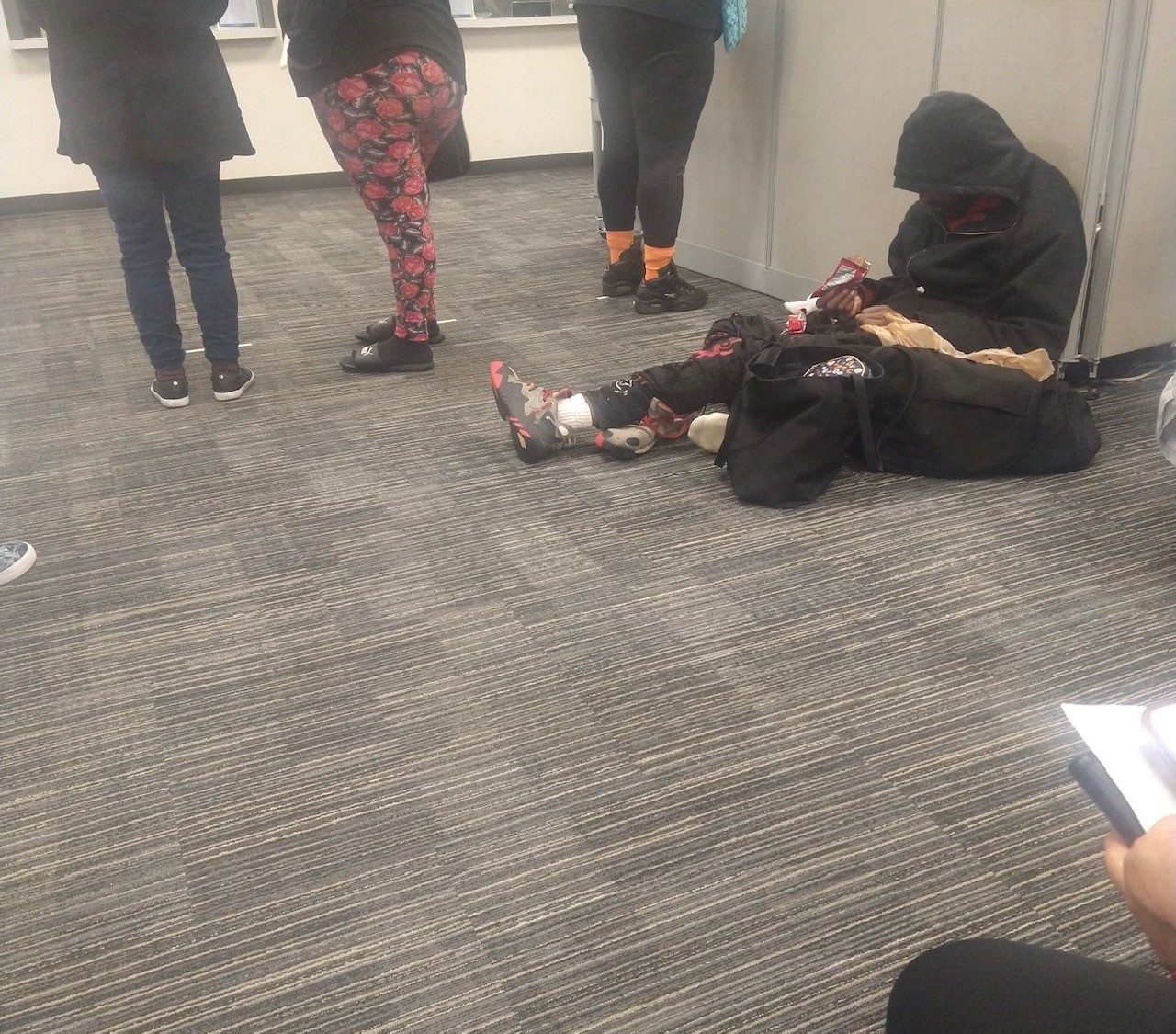 A man sits on the floor at the SNAP benefits office