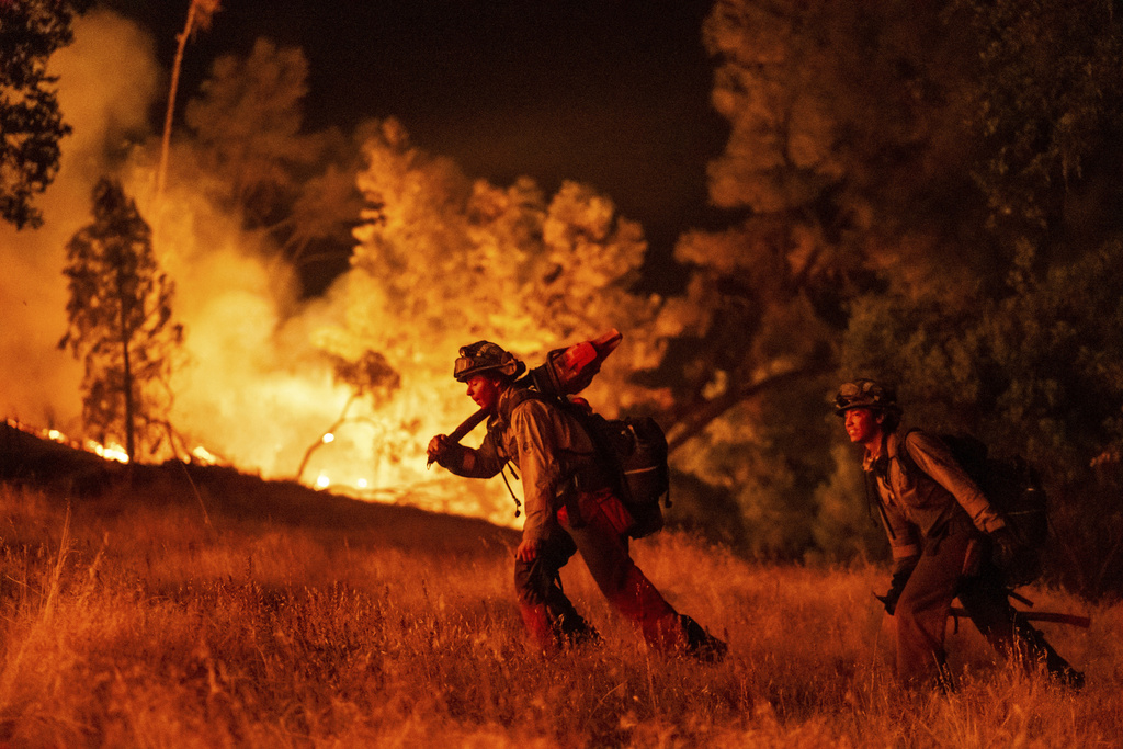 Firefighters battle the Pickett Fire burning in the Aetna Springs area of Napa County, Calif.
