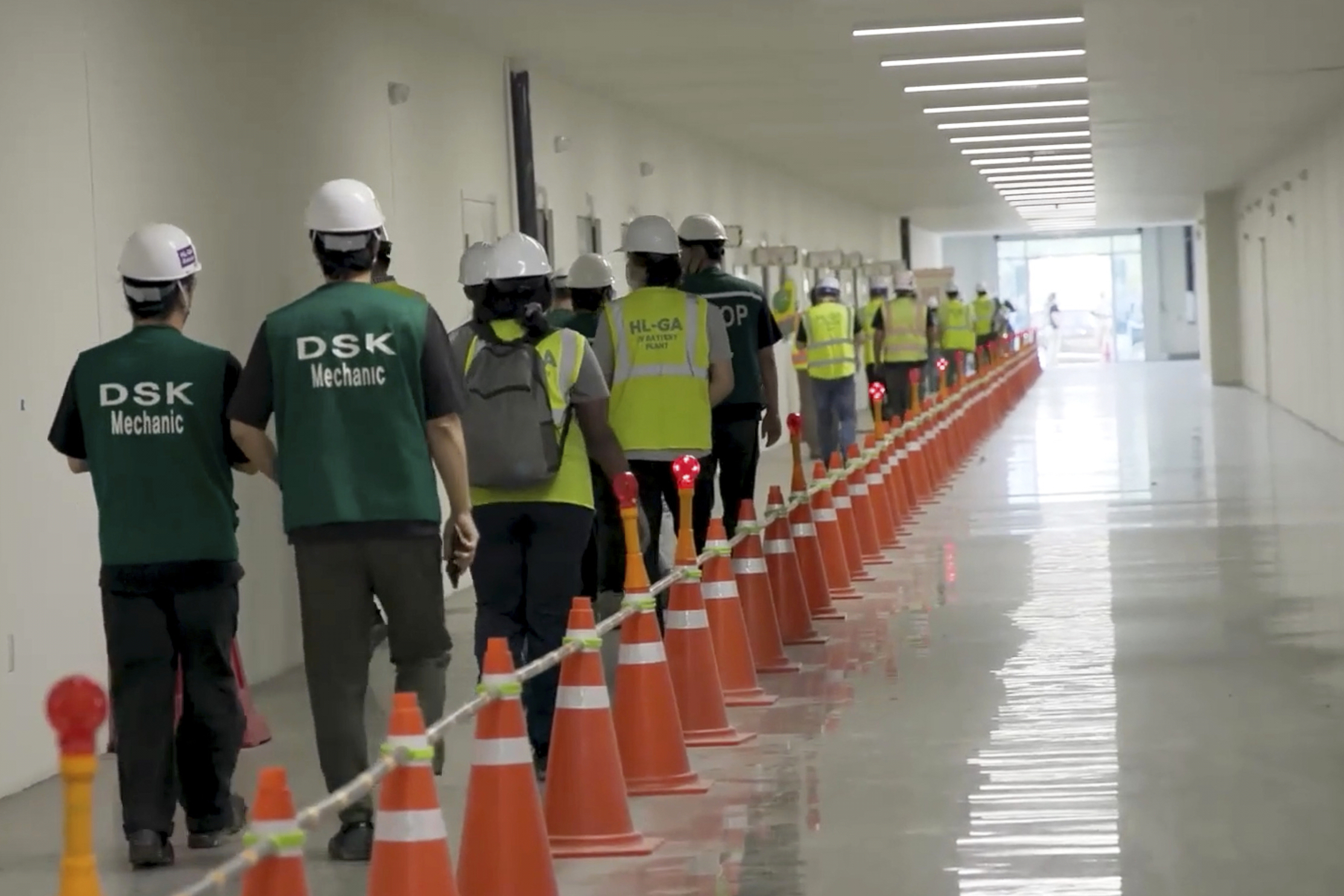 This image from video provided by U.S. Immigration and Customs Enforcement via DVIDS shows manufacturing plant employees being escorted outside the Hyundai Motor Group’s electric vehicle plant, Thursday, Sept. 4, 2025
