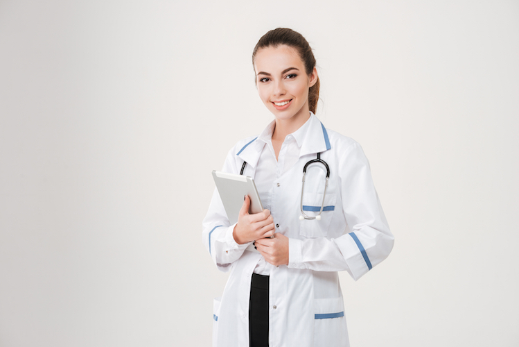 Smiling attractive young woman doctor with stethoscope and tablet
