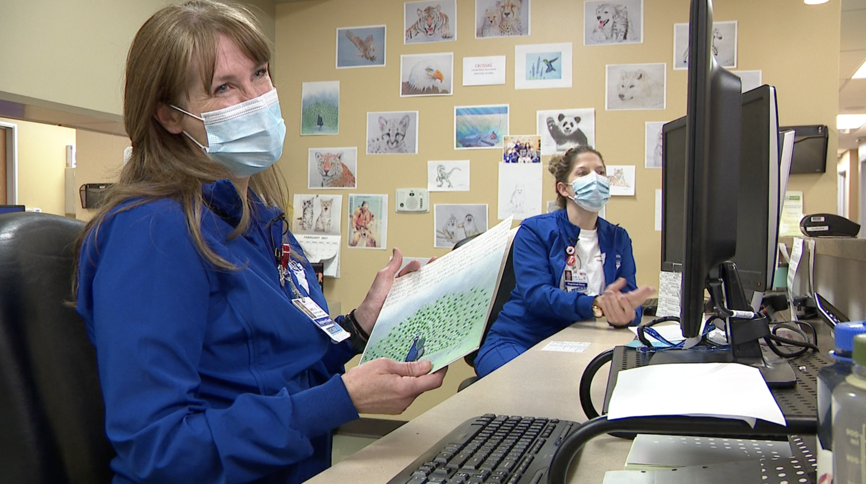 Nurses Darcy Graves and Elise Butler of the Colorado Blood Cancer Institute at Presbyterian/St. Luke's Medical Center share med list artwork drawn by Scotty Magoun
