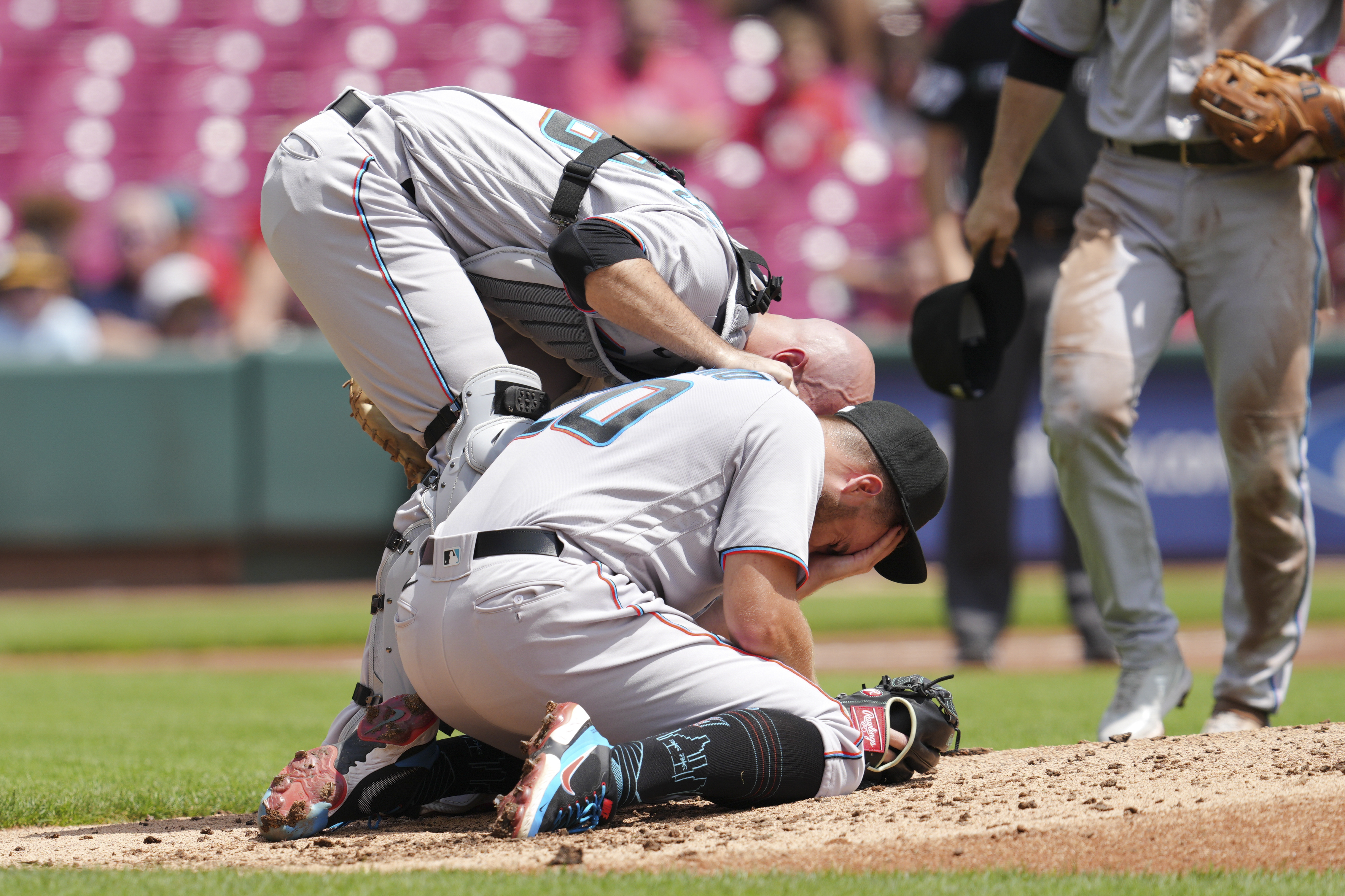 Miami Marlins catcher Jacob Stallings checks on starting pitcher Daniel Castano after being hit in head, July 28, 2022 