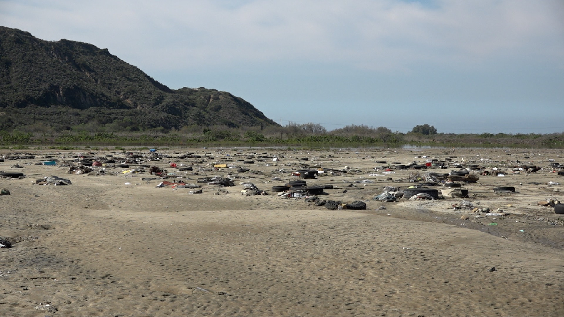 Trash sits in the backyard of a San Ysidro homeowner's property after a levee broke along the Tijuana River near Monument Road.