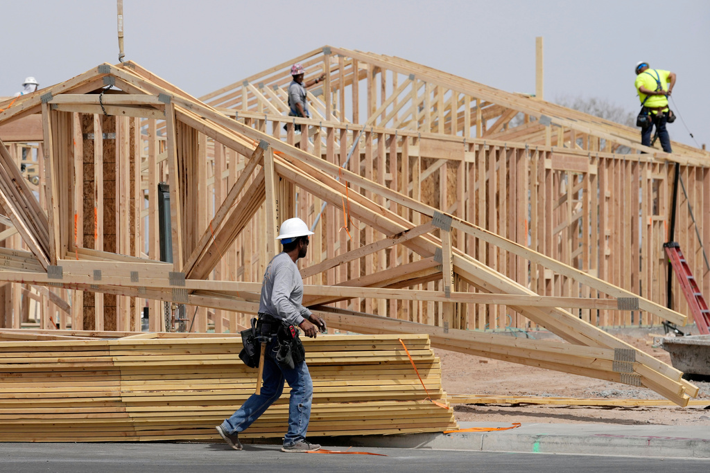 FILE - Construction workers install a lumber roof at a new home build Tuesday, April 1, 2025, in Laveen, Ariz. 
