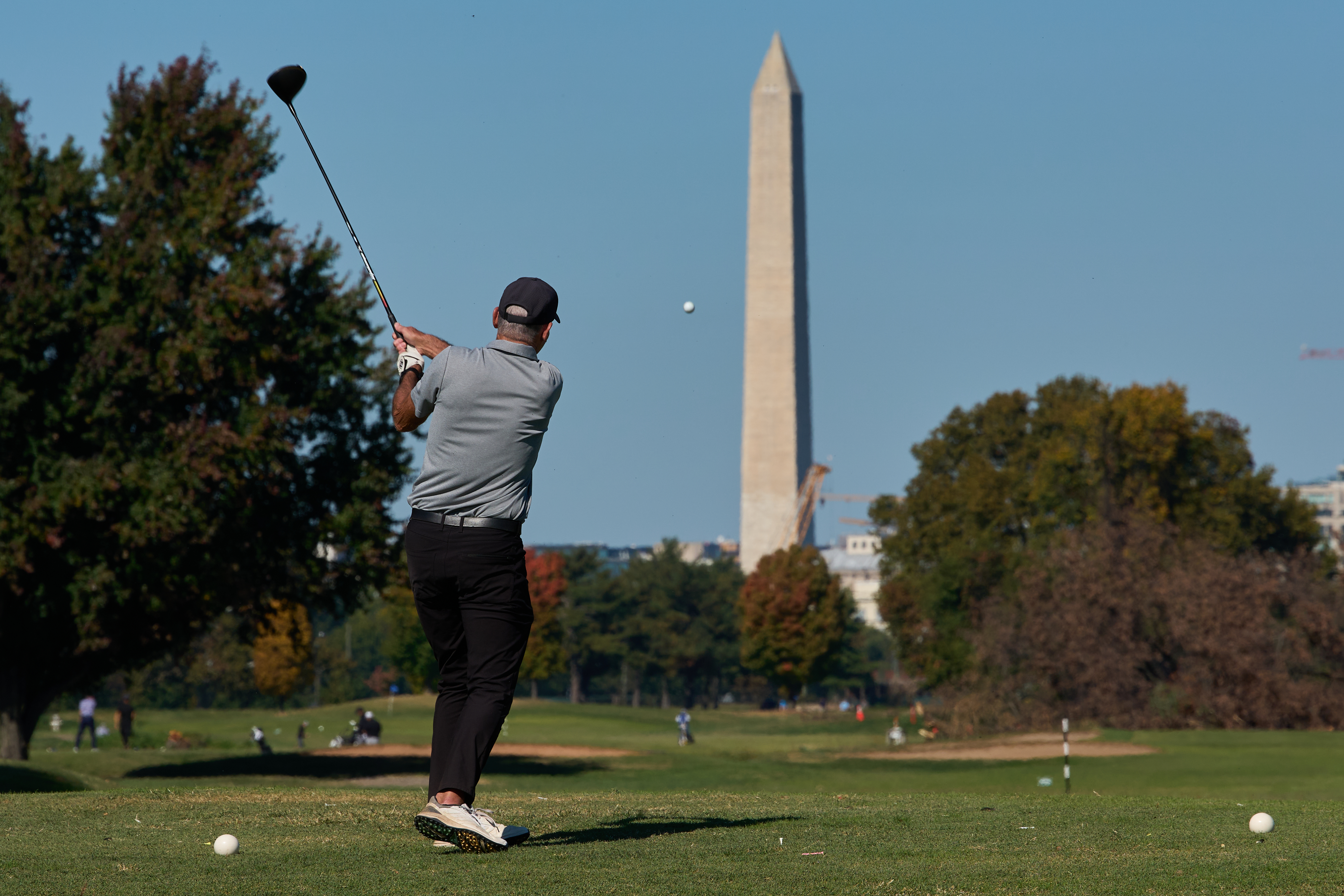 The Washington Monument is seen as a golfer takes a swing at East Potomac Park Golf Course, Monday, Oct. 26, 2026, in Washington. 