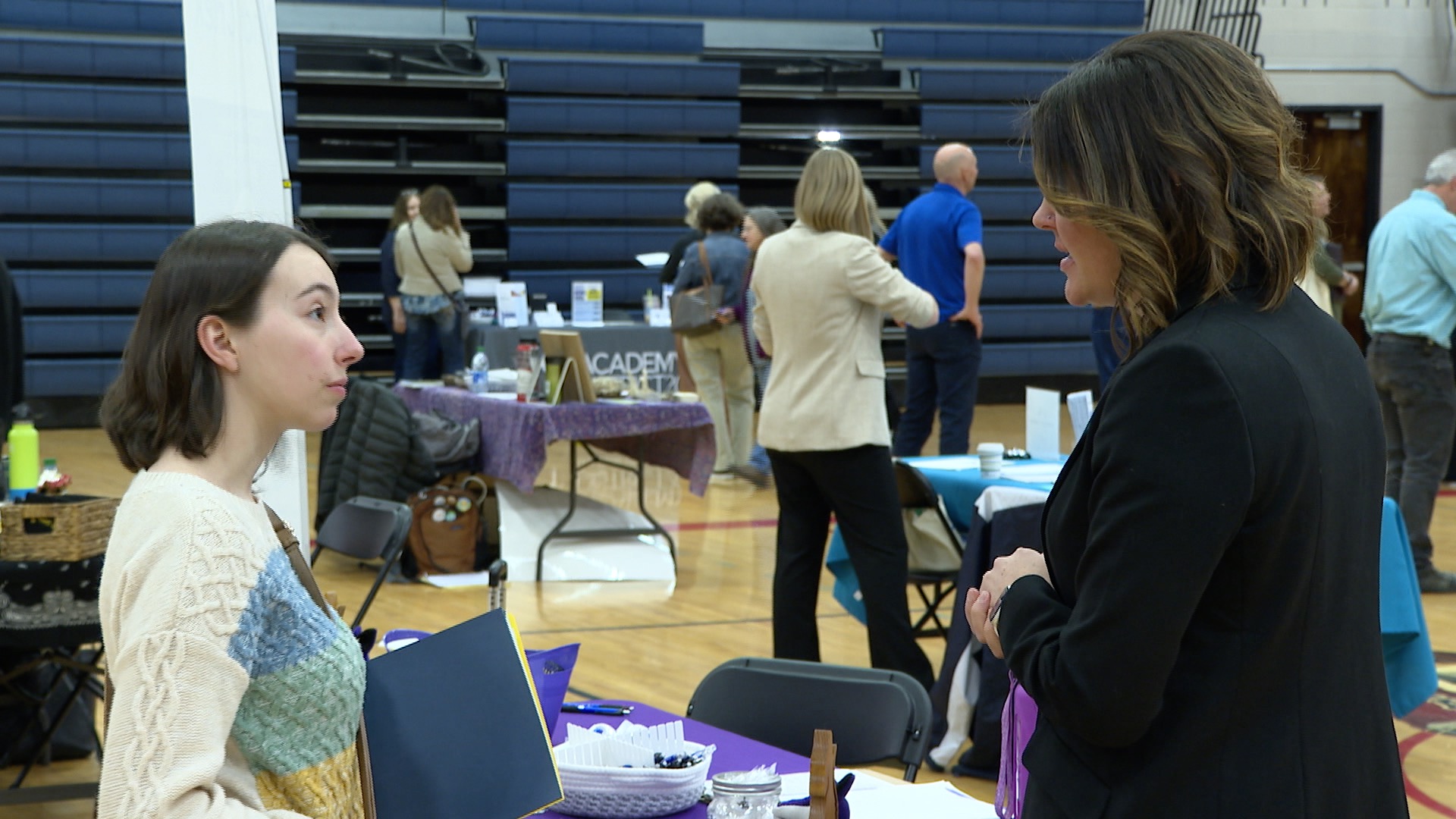 A hiring manager and candidate talk at a job fair 