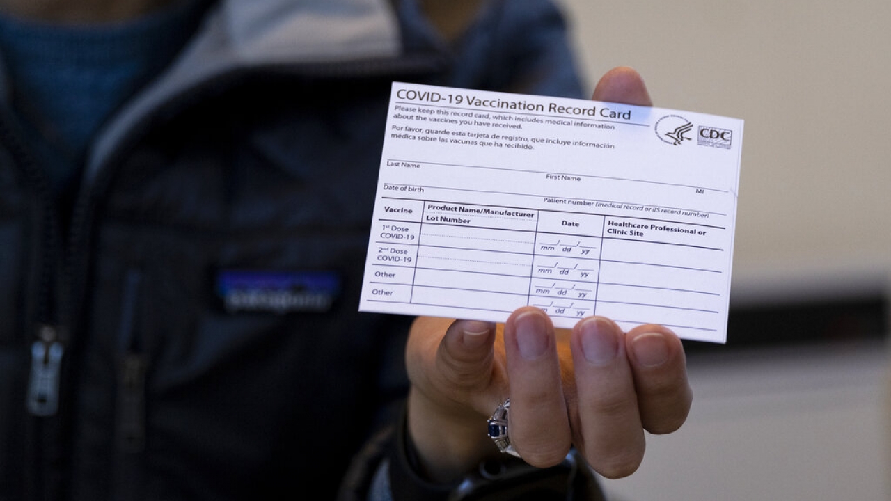 Person holds a COVID-19 vaccination card