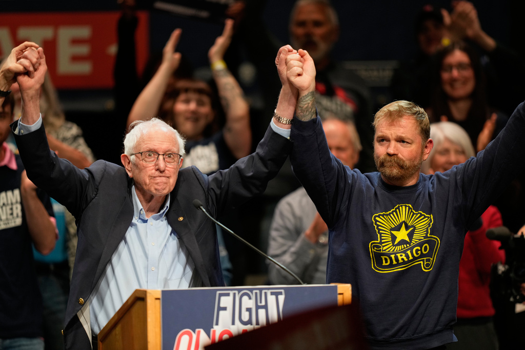 Graham Platner, Democratic candidate for U.S. Senate, and Sen. Bernie Sanders, left, join hands at an event in Orono, Maine, Sunday, May 24, 2026. 