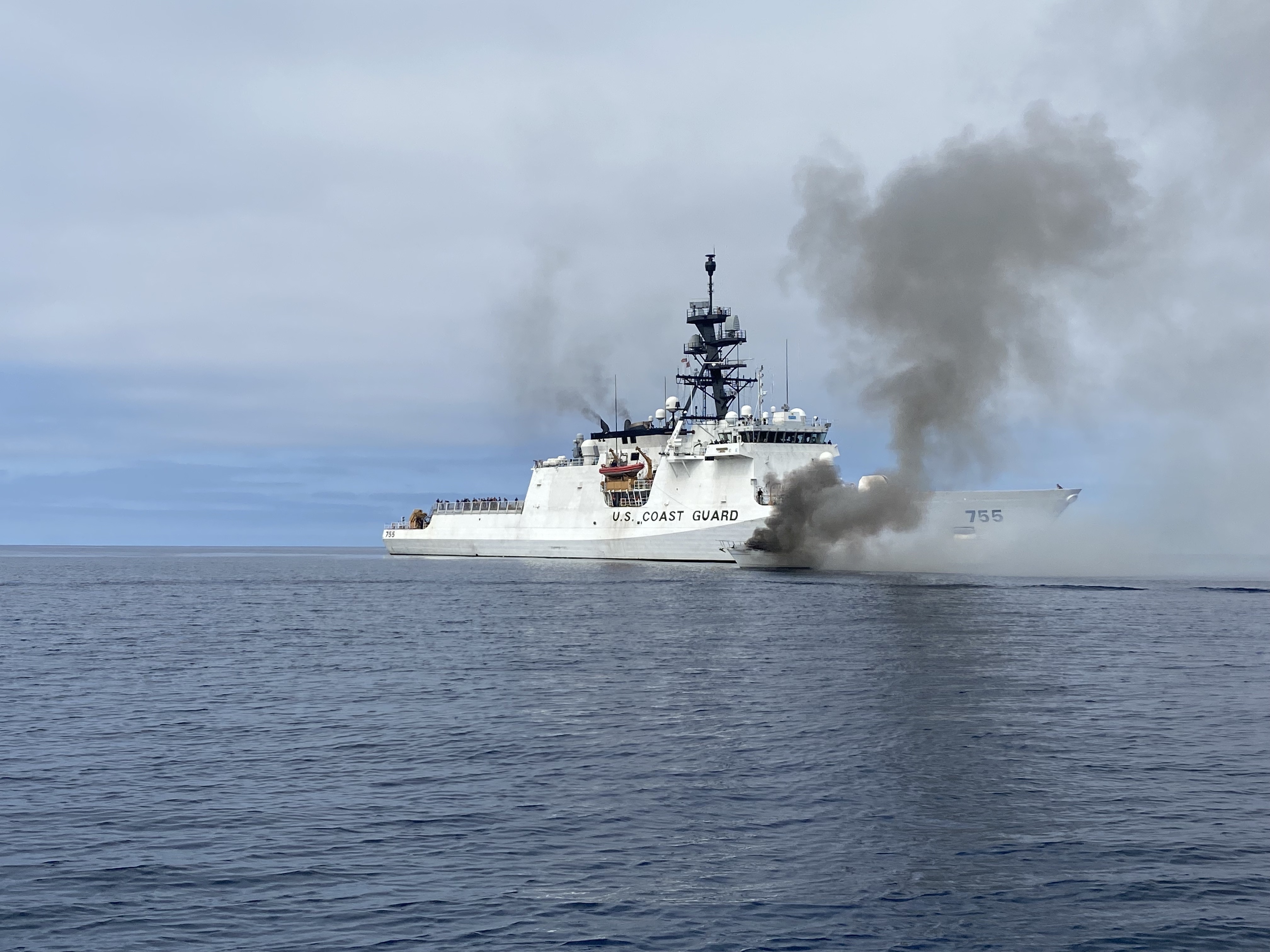 Coast Guard Cutter Munro crewmembers work to extinguish a vessel fire off the San Diego coast