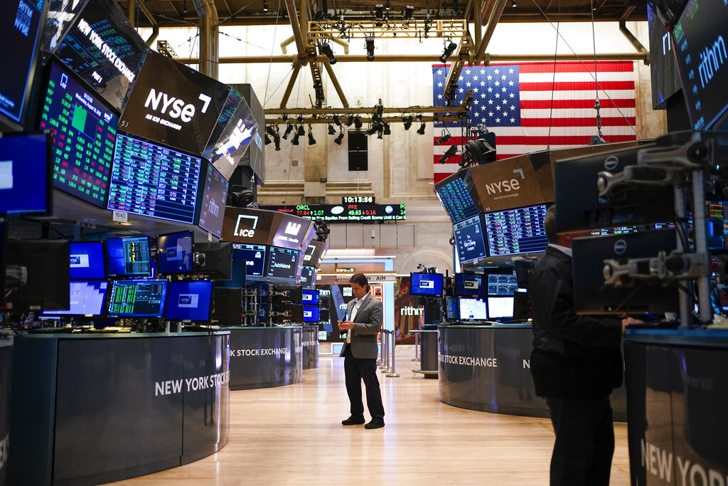 FILE - Traders work on the floor at the New York Stock Exchange in New York, Aug. 10, 2022. 