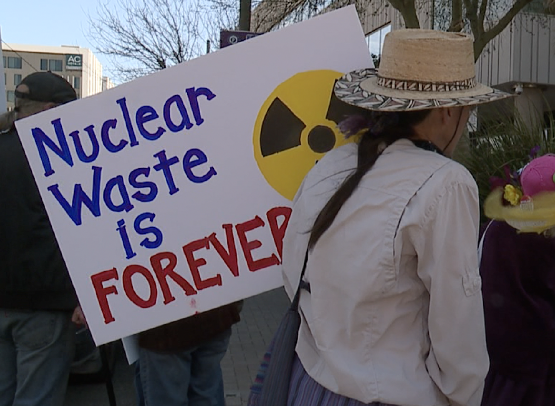 A protestor rallies outside of Tucson Electric Power's downtown Tucson headquarters March 11, 2025