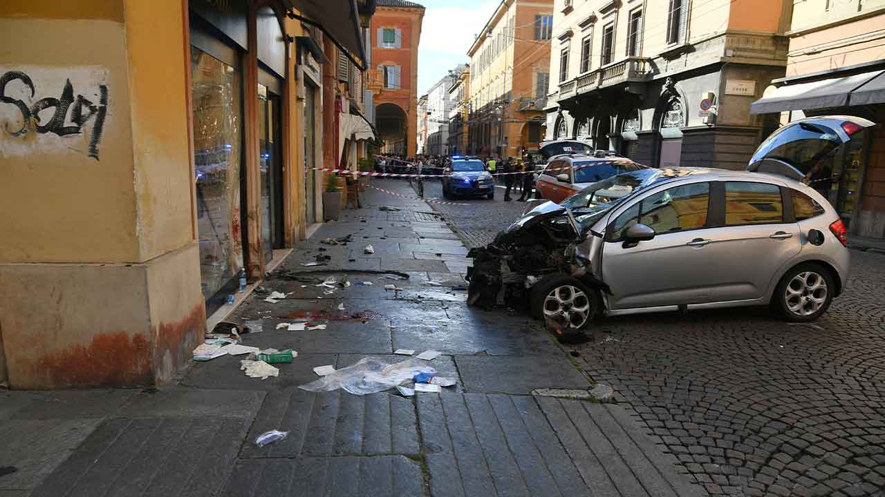 Blood is seen next to a destroyed car on a street of Modena, Italy, Saturday, May 16, 2026. 