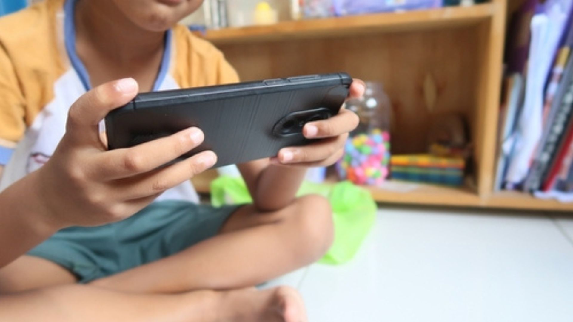Stock image of a young boy on a mobile device.