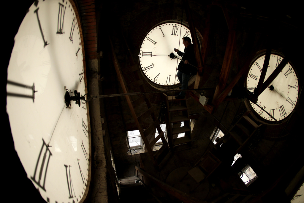  Custodian Ray Keen inspects a clock face before changing the time on the 100-year-old clock atop the Clay County Courthouse, March 8, 2014, in Clay Center, Kansas. 