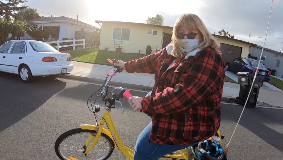 Meghan Craig rides her yellow tricycle.png