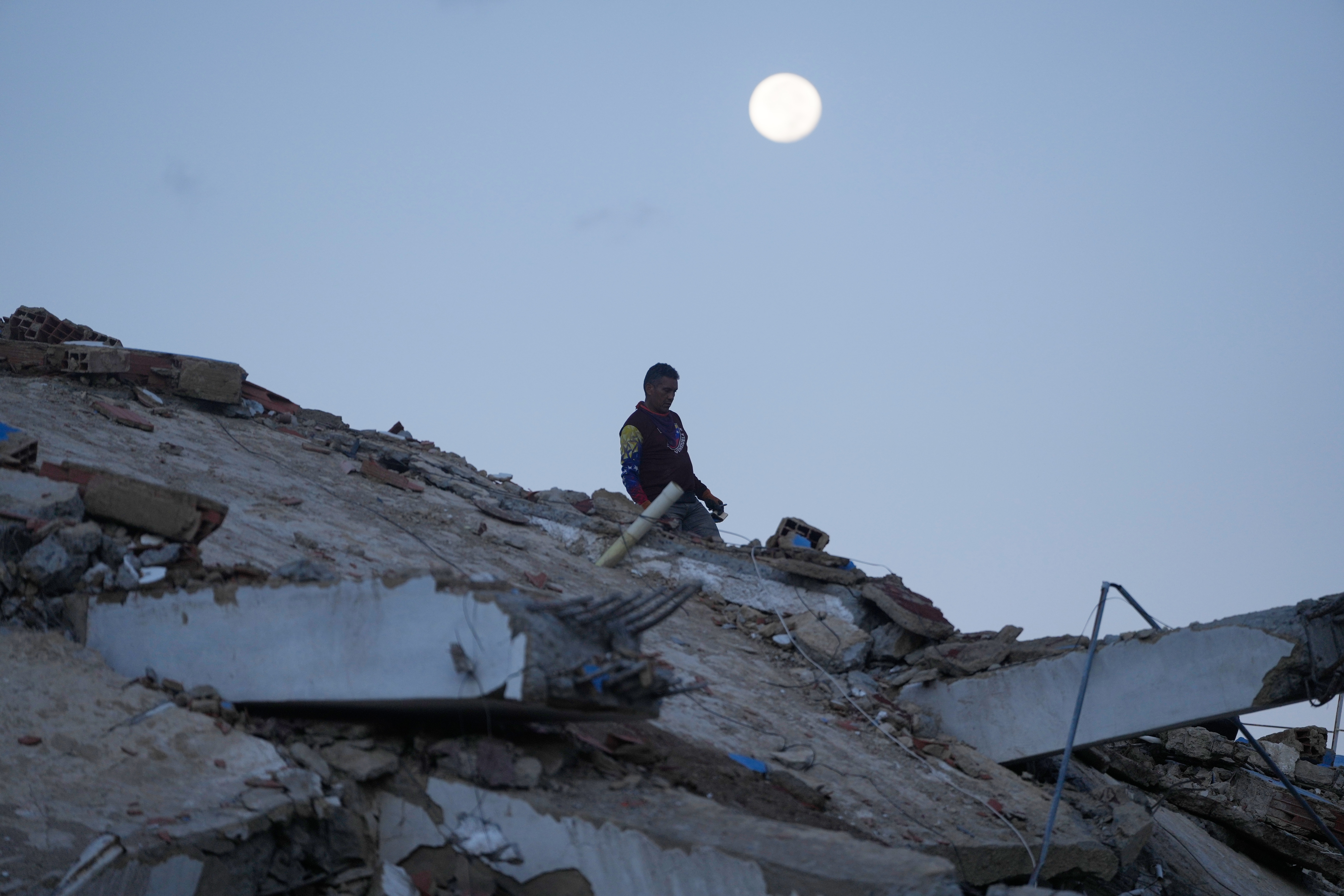 A man walks amid the rubble of a building that collapsed in the earthquakes in La Guaira, Venezuela, Wednesday, July 1, 2026.