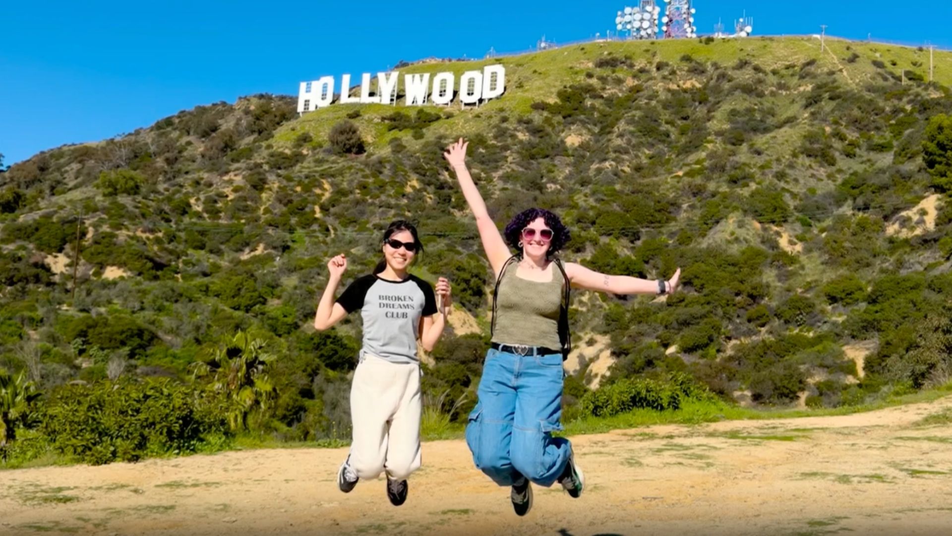 Tourists pose for a photograph in front of the Hollywood sign in Los Angeles, California.
