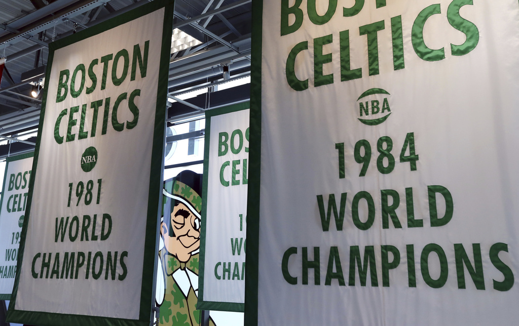 Lucky the Leprechaun, the Boston Celtics team logo, peers out from in between Celtics championship banners hanging in their basketball team practice facility.