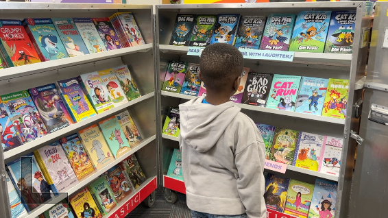 Children picking up books at Riley Elementary school 