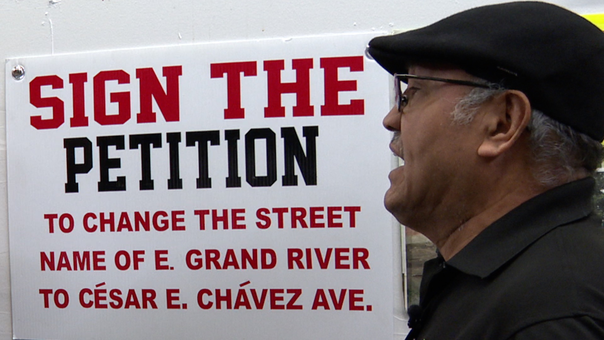 Al Salas speaks in front of Cesar Chavez petition sign