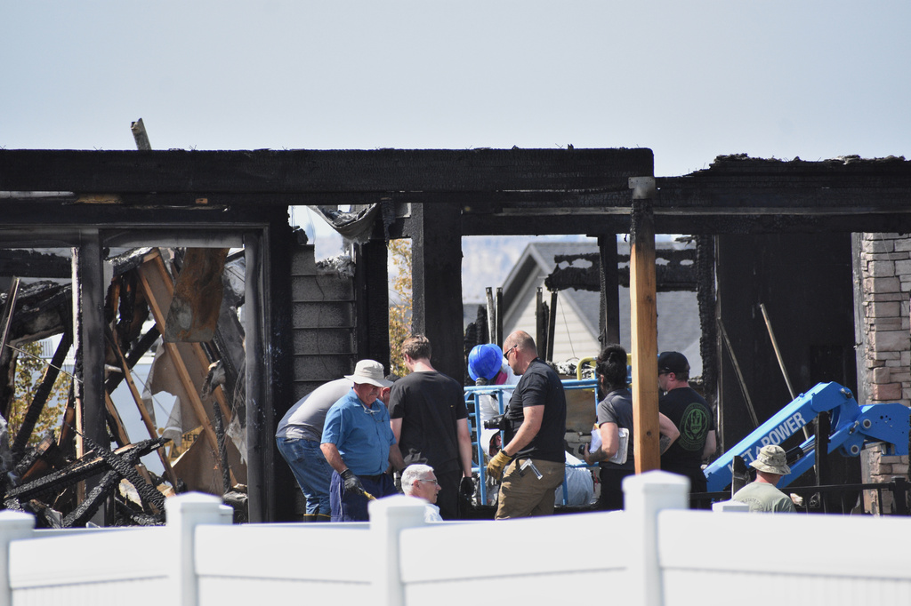 Investigators work at the scene Tuesday, Aug. 25, 2026, where a family was killed and the house burned in Billings, Mont. 
