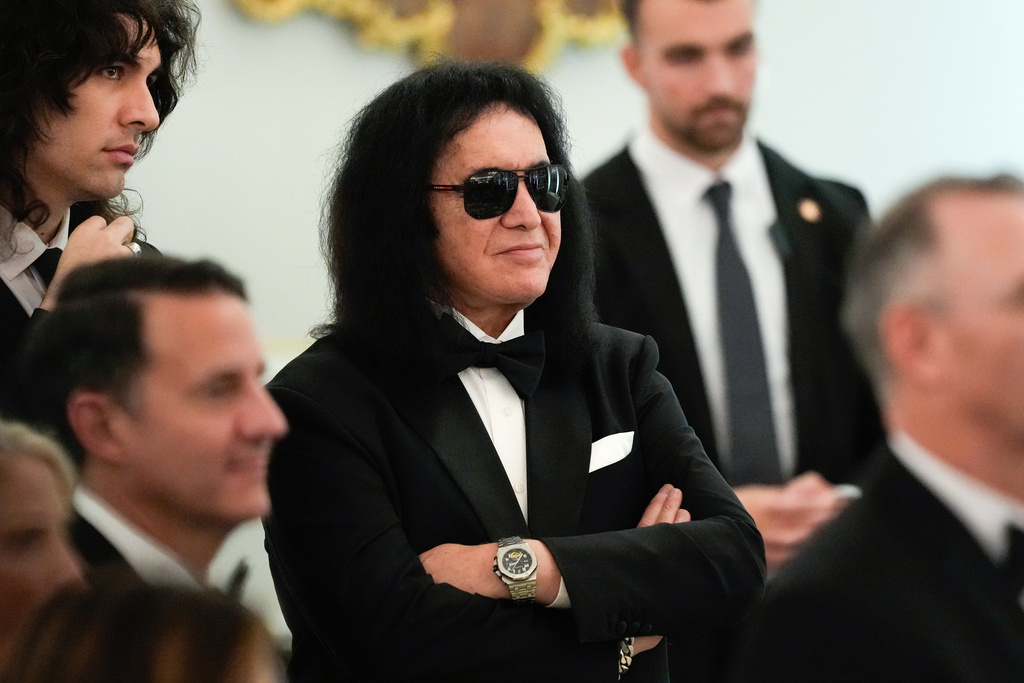 Gene Simmons, a member of the rock band Kiss, stands while listening to President Donald Trump speak during a Kennedy Center Honors reception for recipients Sylvester Stallone, George Strait, Kiss, Gloria Gaynor and Michael Crawford at the State Department, Saturday, Dec. 6, 2025, in Washington. 