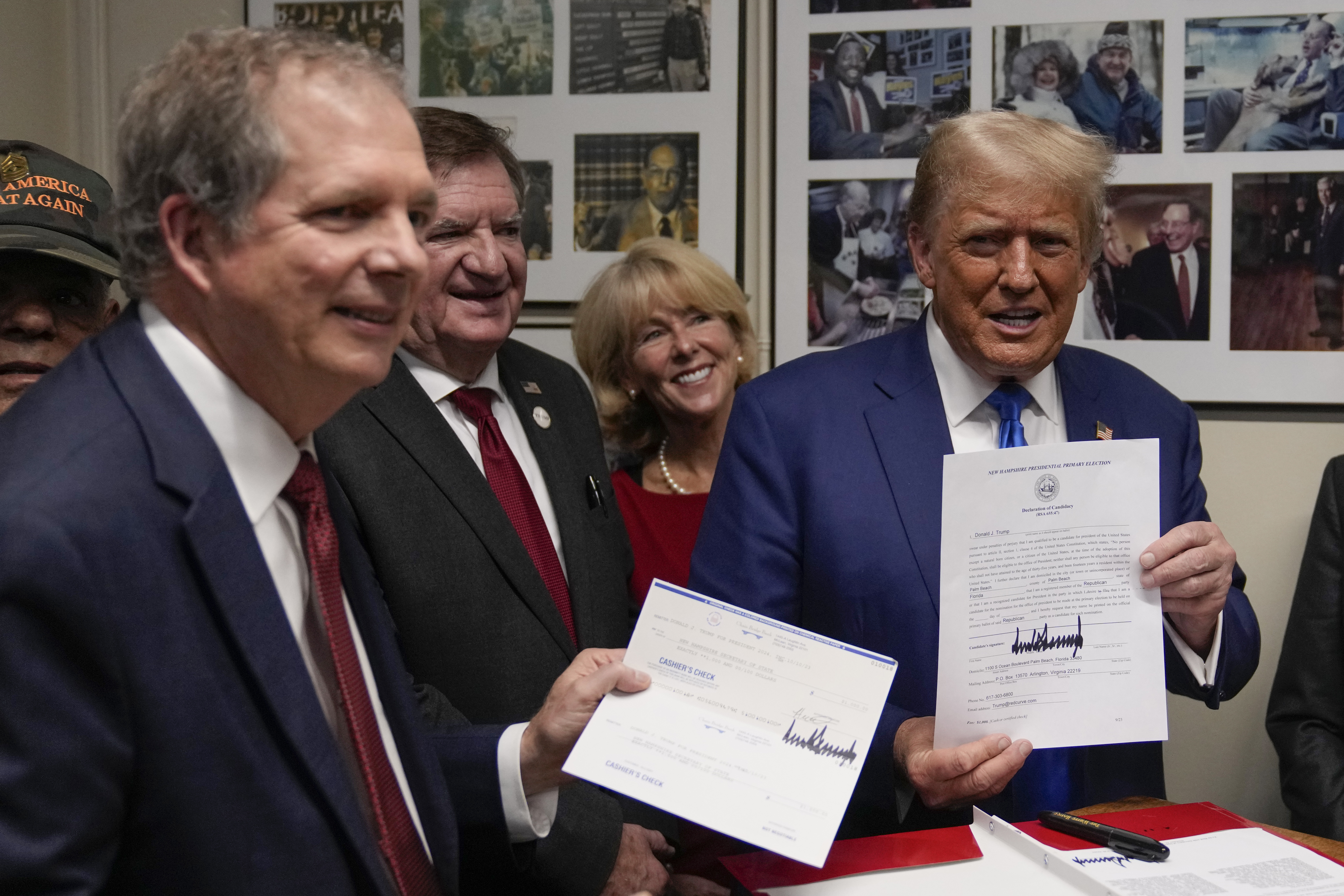 Republican presidential candidate former President Donald Trump talks with New Hampshire Secretary of State David Scanlan, left, as he signs papers to be on the 2024 Republican presidential primary ballot at the New Hampshire Statehouse, Monday, Oct. 23, 2023, in Concord, N.H. (AP Photo/Charles Krupa)