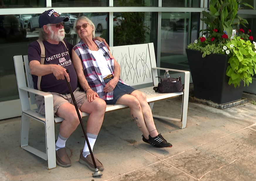 Al Gransee, 77, and Deb Robertson, 73, sit on a bench outside Nebraska Medicine in Bellevue.