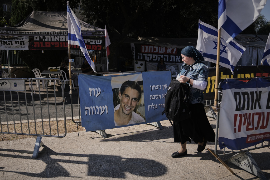 A woman walks past a photo of Hadar Goldin, an Israeli soldier killed in 2014 whose body has been held in Gaza since then.